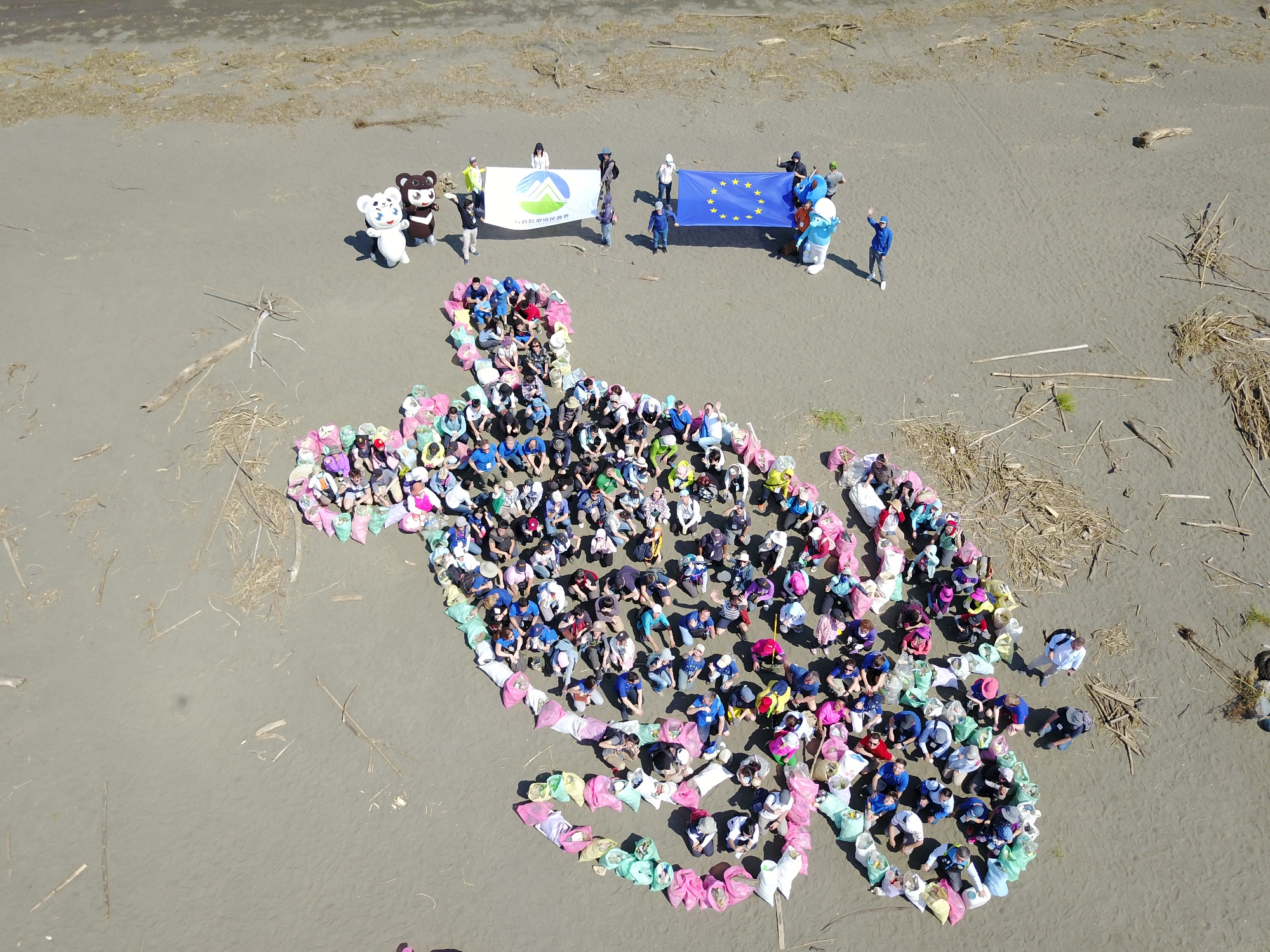 全體淨灘人員將拾獲垃圾排列出海龜地景圖，呼籲對抗塑膠污染.jpg